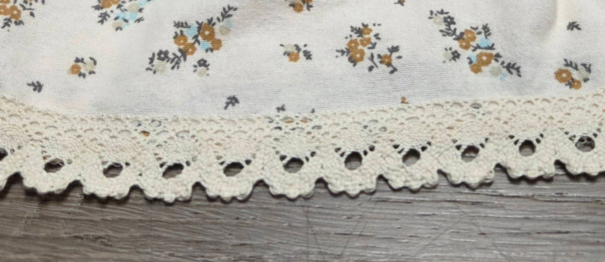 Close-up of cream scalloped lace hem on LP-11 floral pajama pants