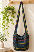 Thai woven shoulder bag BC-06 - lifestyle editorial hanging on wood hooks with plants